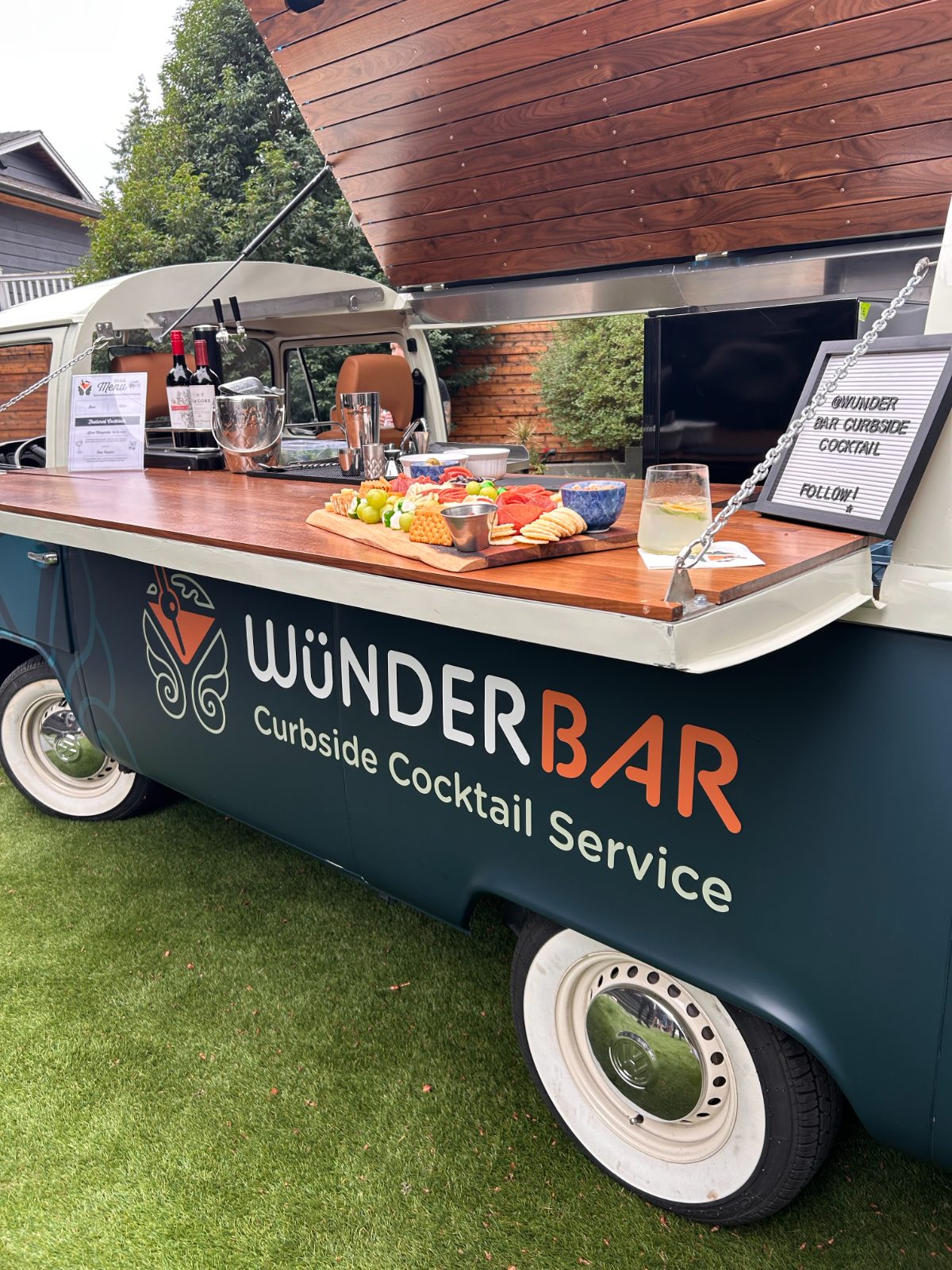 Wünderbar branding on the side of the bus with a charcuterie board on the bar